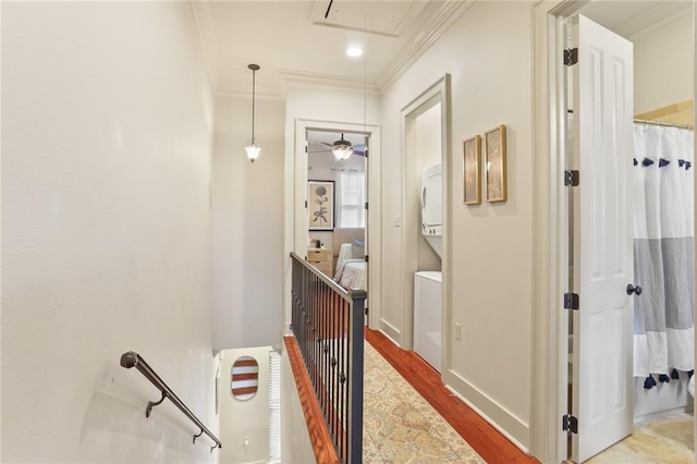 corridor with baseboards, attic access, ornamental molding, an upstairs landing, and wood finished floors