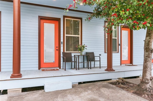 view of exterior entry featuring covered porch