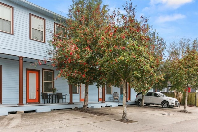 view of property with a porch and fence