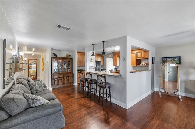 interior space with dark wood-style floors, visible vents, and baseboards