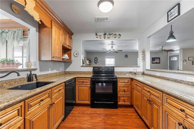 kitchen featuring visible vents, black range with electric stovetop, dark wood-type flooring, brown cabinets, and a sink