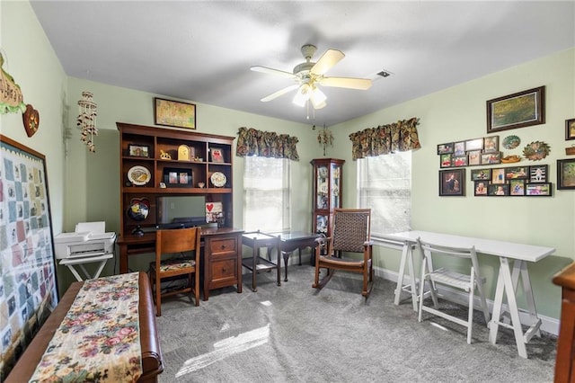 office featuring baseboards, visible vents, carpet floors, and ceiling fan