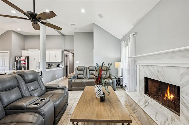 living area with visible vents, high vaulted ceiling, light wood-style floors, a fireplace, and ceiling fan