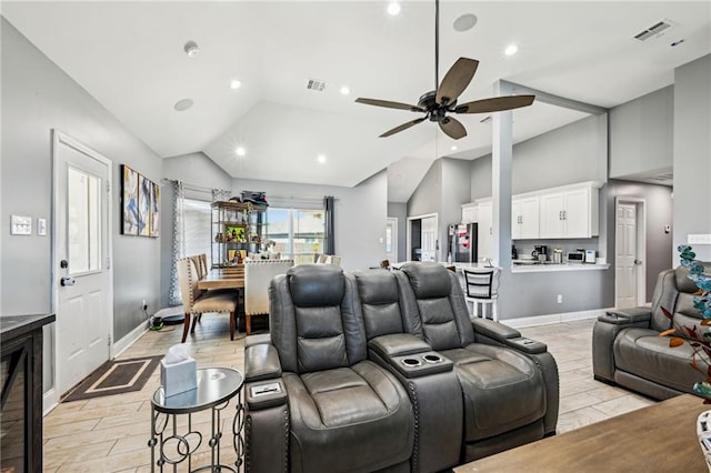 cinema room featuring visible vents, light wood-style flooring, a ceiling fan, and lofted ceiling