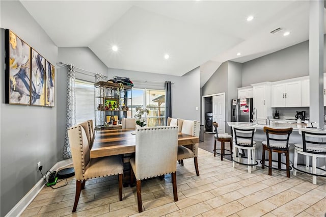 dining space featuring visible vents, baseboards, light wood-type flooring, vaulted ceiling, and recessed lighting