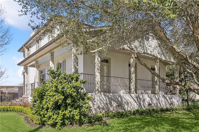 view of side of home featuring stucco siding and a yard