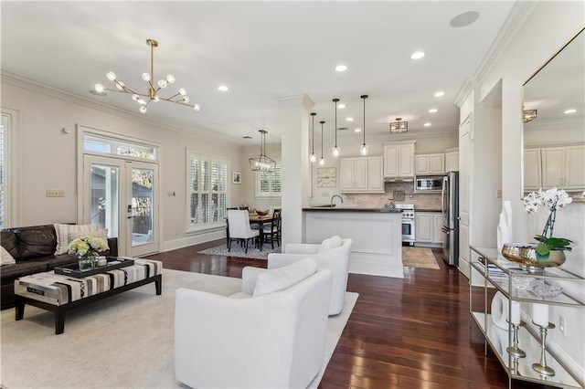 living room with a chandelier, dark wood-type flooring, and ornamental molding