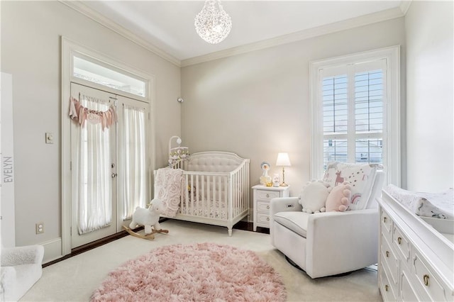 bedroom featuring multiple windows, a nursery area, light carpet, and crown molding