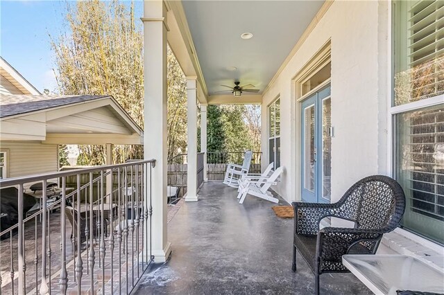 balcony with french doors, a ceiling fan, covered porch, and a sunroom