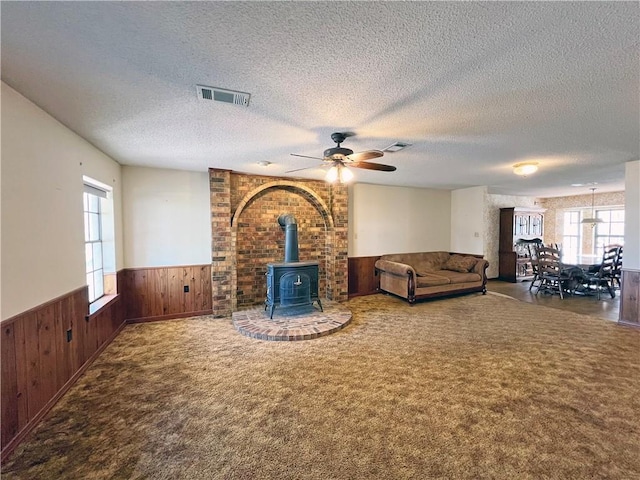 unfurnished living room with visible vents, carpet, and a wainscoted wall