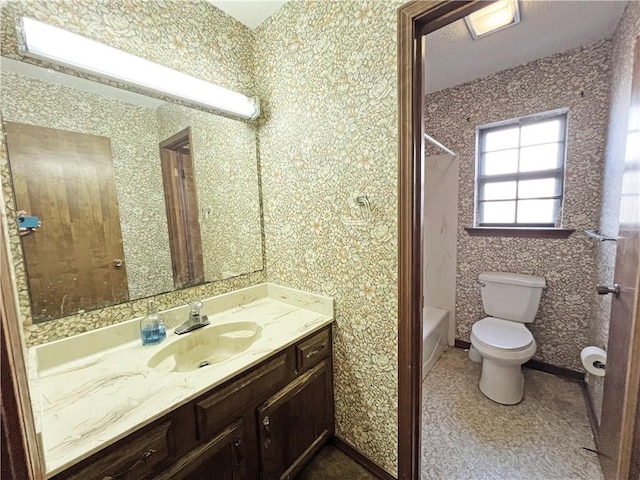 bathroom with toilet,  shower combination, and vanity