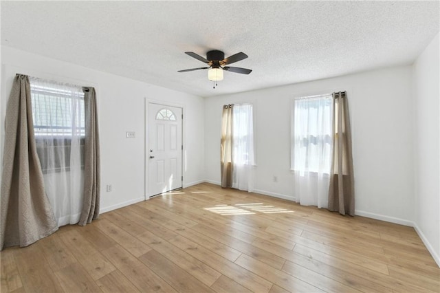 entrance foyer with baseboards, light wood-style flooring, a textured ceiling, and a ceiling fan