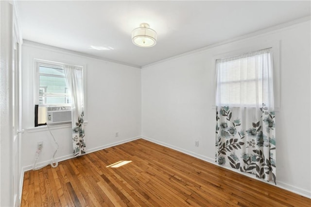 unfurnished room featuring cooling unit, baseboards, and wood-type flooring