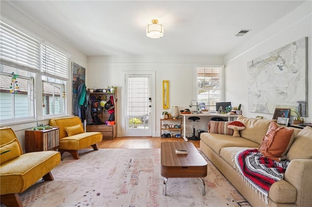 living area with wood finished floors and visible vents