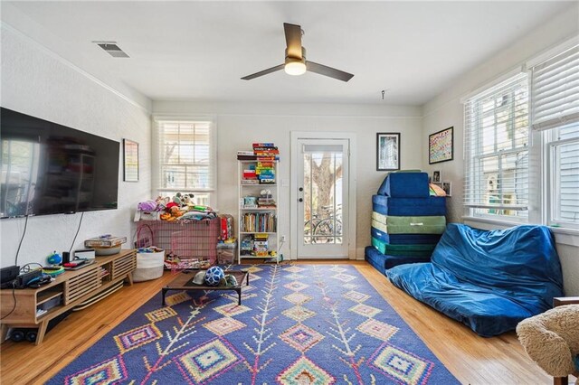 interior space with visible vents, a healthy amount of sunlight, ceiling fan, and wood finished floors