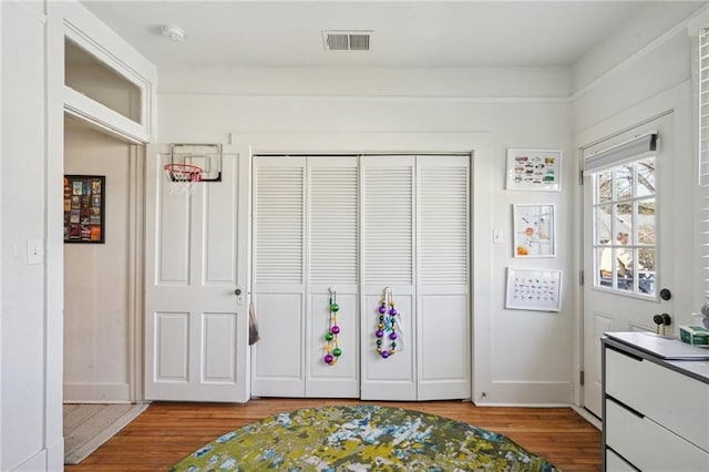 interior space featuring visible vents, baseboards, a closet, and wood finished floors