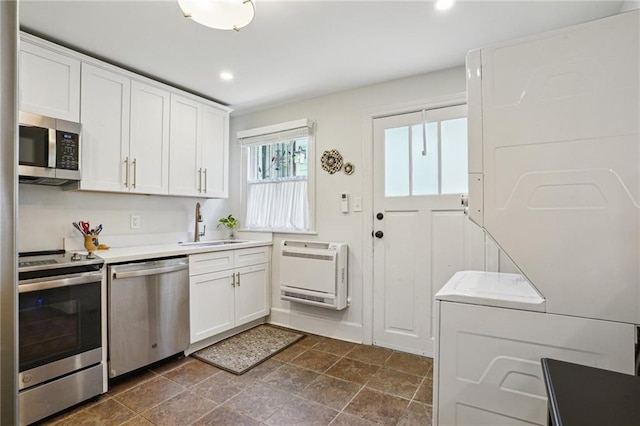 kitchen featuring a sink, white cabinets, heating unit, and stainless steel appliances