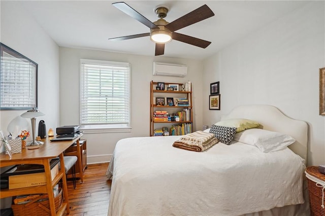 bedroom with baseboards, an AC wall unit, a ceiling fan, and hardwood / wood-style flooring