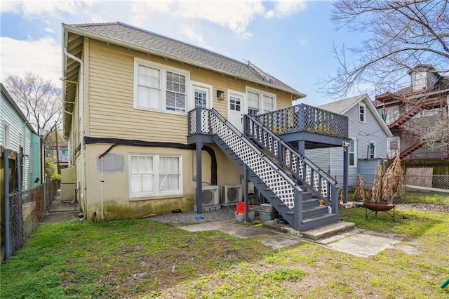 back of house with stairway, a deck, a lawn, and a fenced backyard