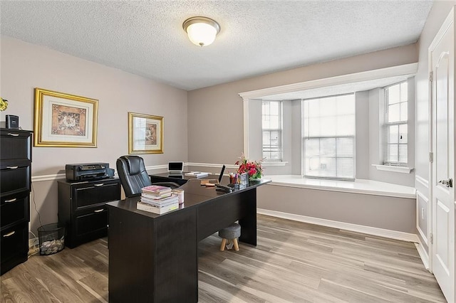 home office with wood finished floors, baseboards, and a textured ceiling