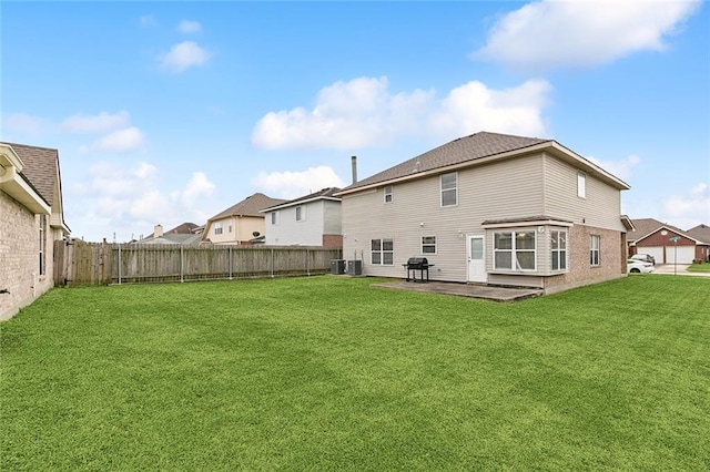 rear view of property with a fenced backyard, cooling unit, a patio, and a yard