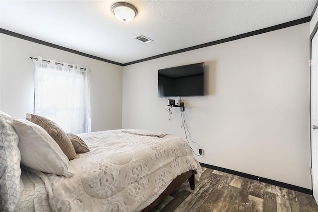 bedroom with dark wood finished floors, baseboards, ornamental molding, and visible vents
