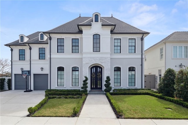 french country inspired facade featuring stucco siding, an attached garage, concrete driveway, and a front lawn