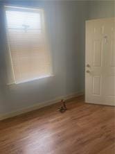 unfurnished room with baseboards and wood finished floors