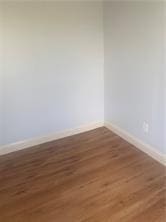 spare room with wood finished floors and baseboards