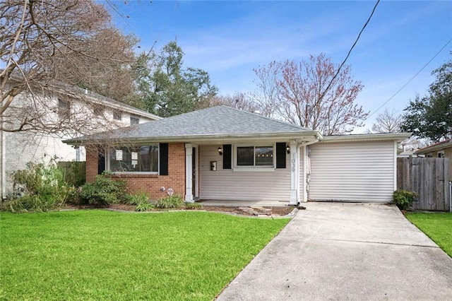 view of front of house featuring brick siding, fence, concrete driveway, roof with shingles, and a front yard