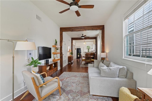 living area featuring wood finished floors, a ceiling fan, visible vents, and baseboards