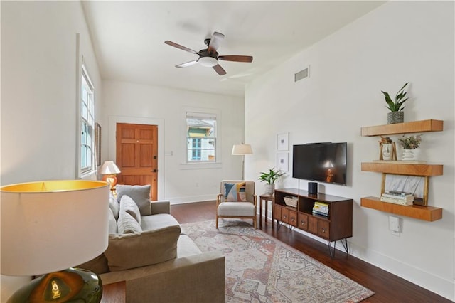 living room with wood finished floors, baseboards, visible vents, and ceiling fan