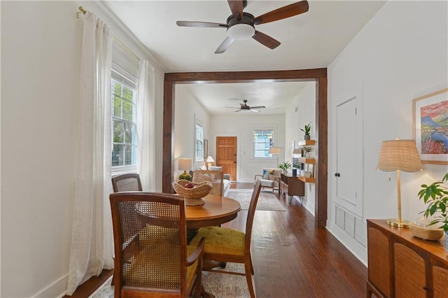 dining space with dark wood finished floors, baseboards, a wealth of natural light, and ceiling fan