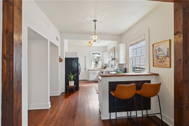 kitchen featuring dark wood-style floors, visible vents, white cabinets, and baseboards