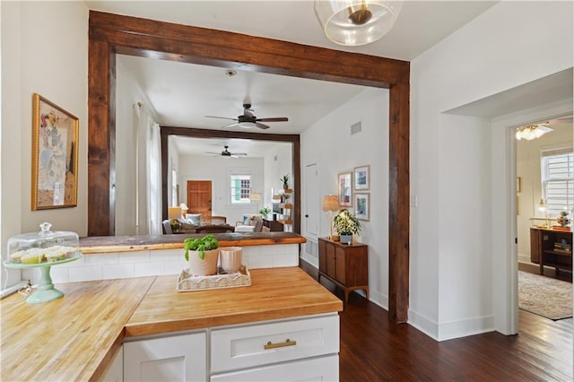 kitchen with visible vents, dark wood finished floors, plenty of natural light, white cabinetry, and wood counters