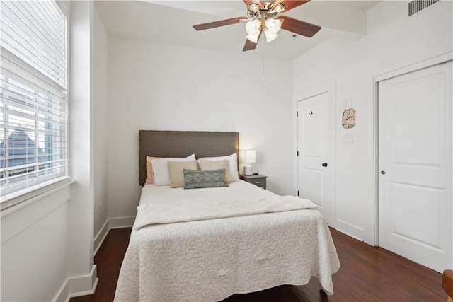 bedroom featuring wood finished floors, visible vents, a closet, and baseboards