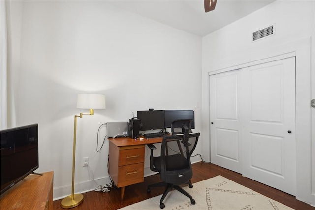 home office with a ceiling fan, dark wood-style floors, visible vents, and baseboards