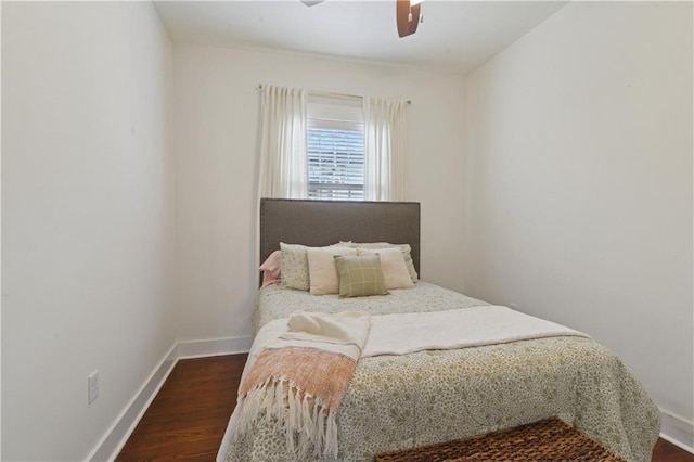 bedroom with a ceiling fan, baseboards, and dark wood-style flooring