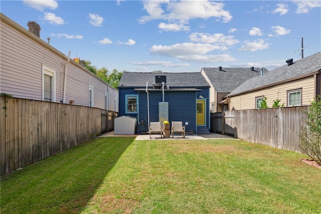 rear view of property featuring entry steps, a patio, a fenced backyard, and a lawn