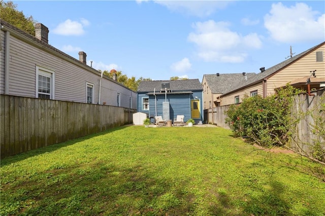 view of yard with a storage unit, an outdoor structure, and a fenced backyard