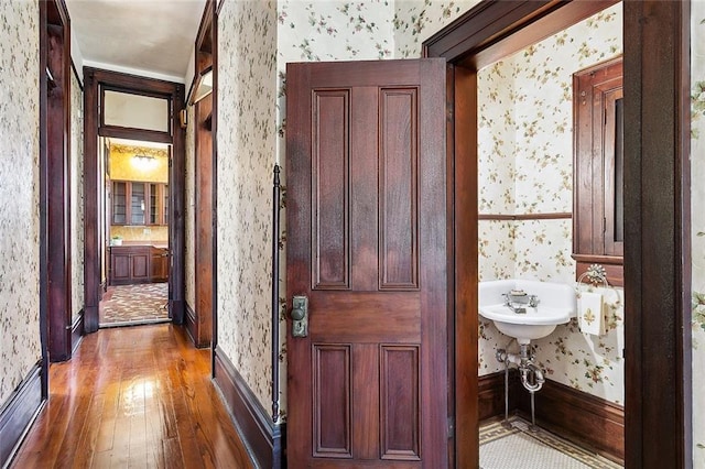 corridor featuring hardwood / wood-style flooring and wallpapered walls