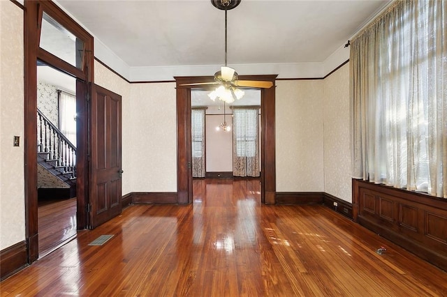 unfurnished dining area with visible vents, crown molding, baseboards, stairway, and hardwood / wood-style floors