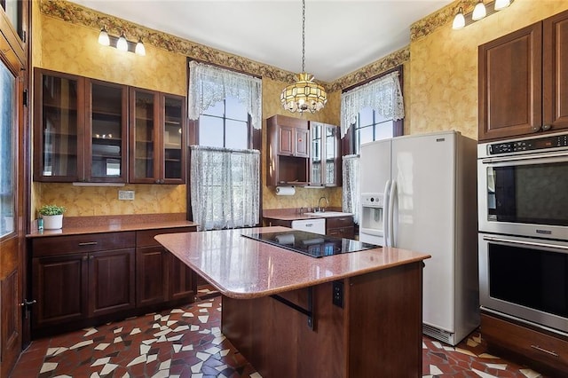 kitchen featuring a kitchen island, glass insert cabinets, black electric stovetop, double oven, and white refrigerator with ice dispenser