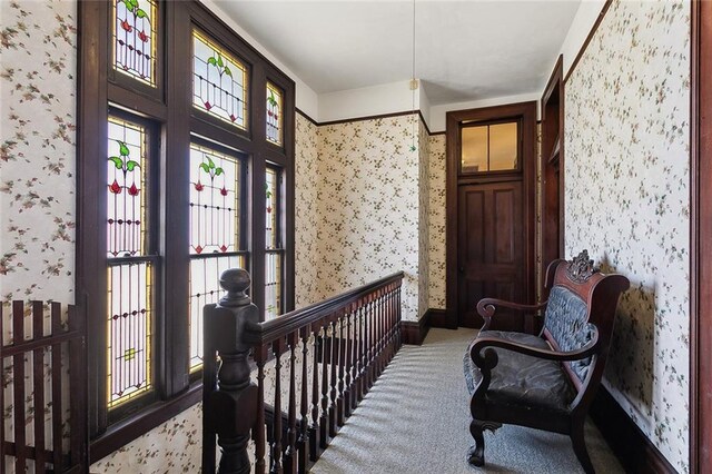 interior space with baseboards, carpet, and wallpapered walls