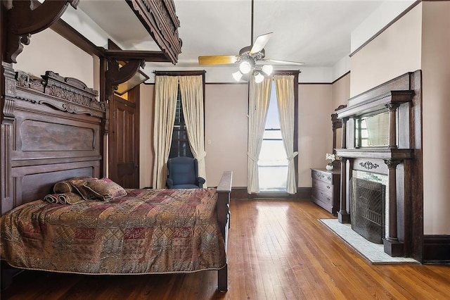 bedroom featuring hardwood / wood-style flooring and a fireplace