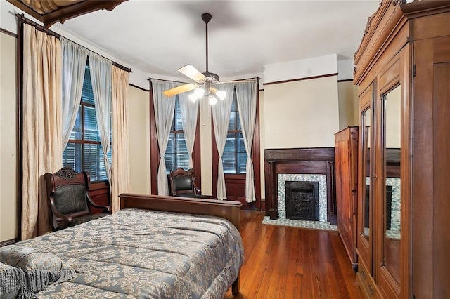 bedroom with a fireplace with flush hearth and wood finished floors