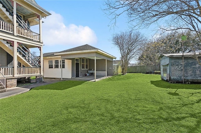 view of yard with stairway, a fenced backyard, an outdoor structure, a storage shed, and a patio area