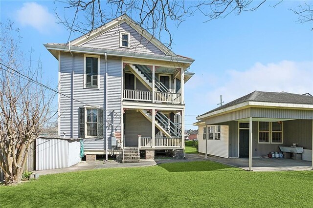 back of house featuring stairs, a patio, and a yard