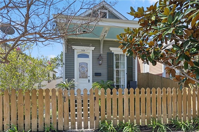 shotgun-style home featuring a fenced front yard