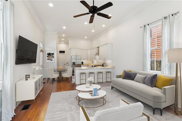 8428 Willow St, New Orleans, LA 70118 - living room with crown molding, healthy amount of natural light, a ceiling fan, wood finished floors, and recessed lighting
